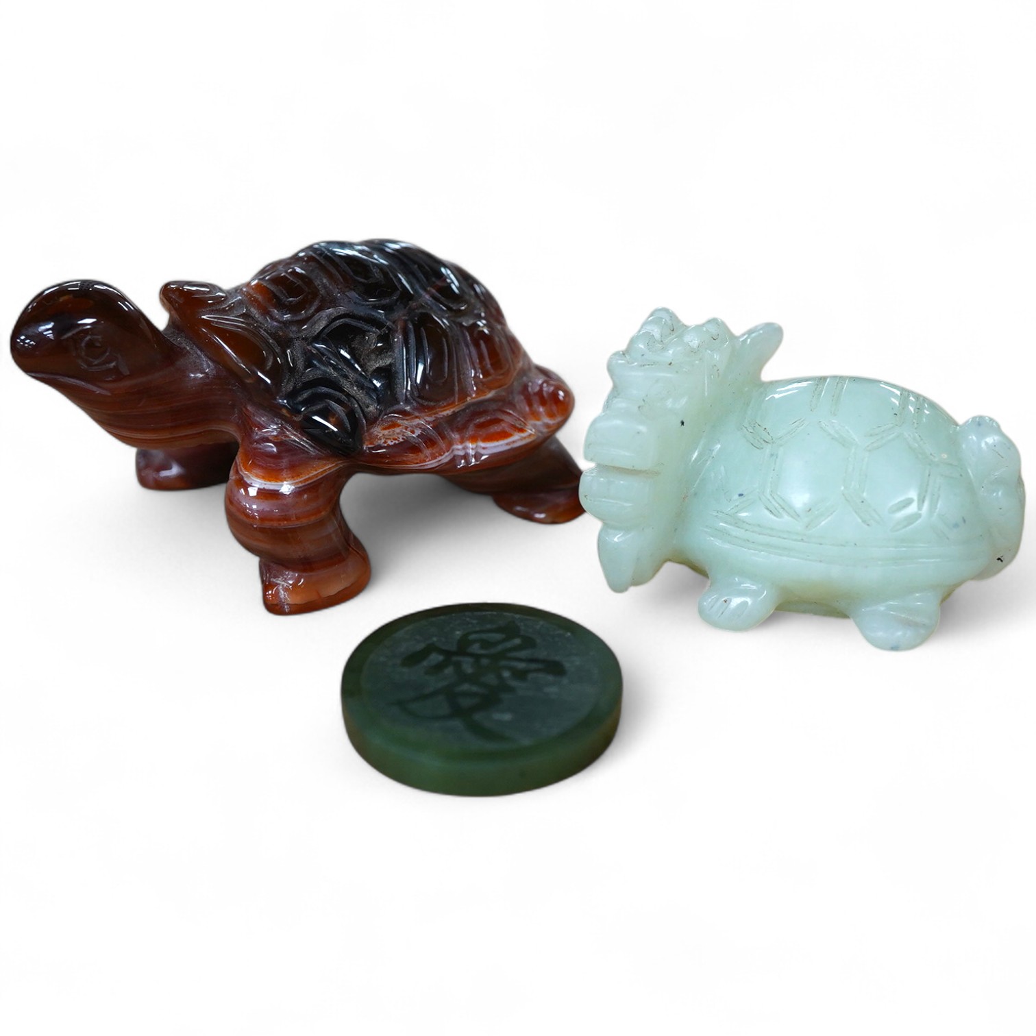 A Chinese carved jade pendant and two hardstone carved animals, pendant 3cm diameter.